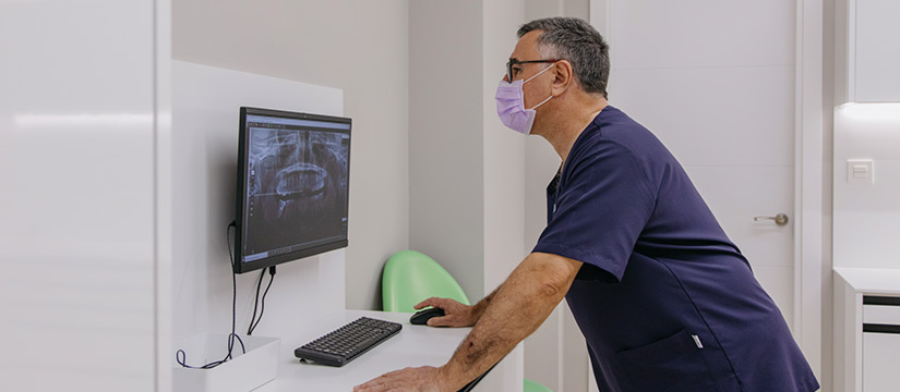 Doctor observa problemas paciente de ortodoncia en ordenador