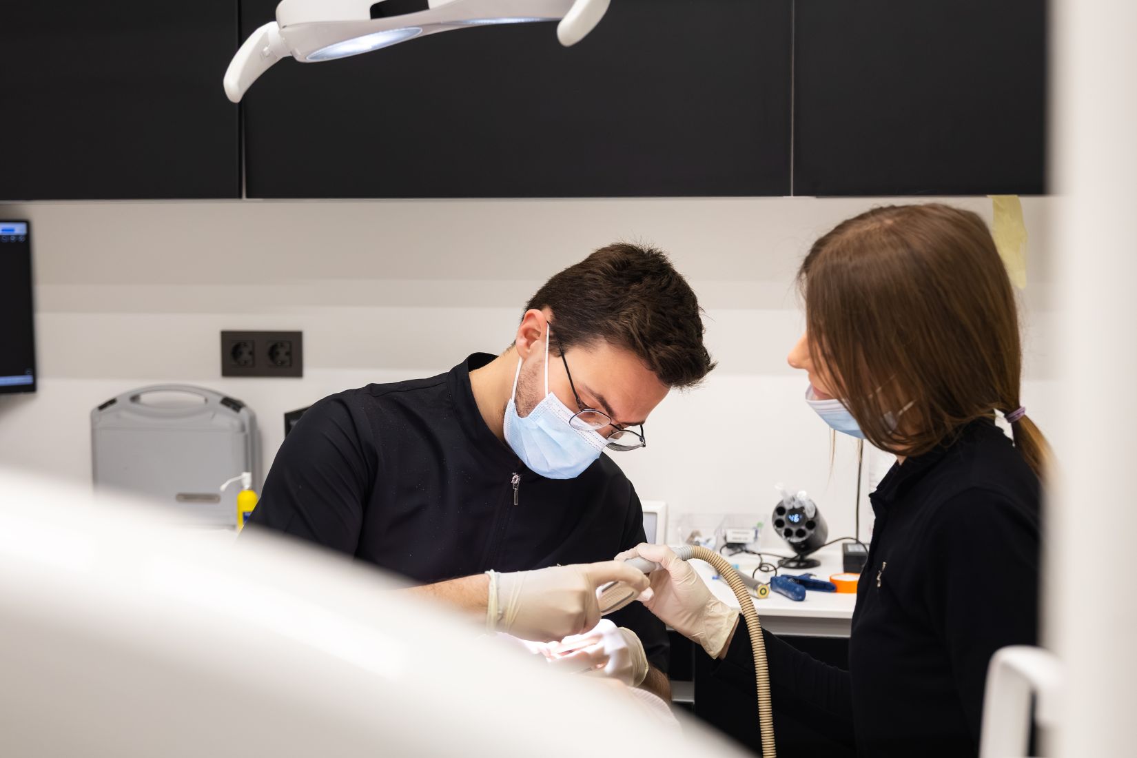 Primer plano de un odontólogo durante un tratamiento dental con una paciente